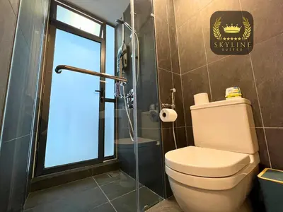 a bathroom with a toilet and a glass shower at The Colony Skyline Suites KLCC in Kuala Lumpur