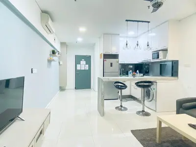 a kitchen with a counter and two stools in it at Mercu Summer Suites KLCC by GRIHOZ Homestay in Kuala Lumpur