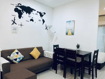 a living room with a couch and a table at Mercu Summer Suites KLCC by GRIHOZ Homestay in Kuala Lumpur