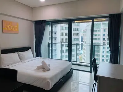 a bedroom with a bed and a large window at Mercu Summer Suites KLCC by GRIHOZ Homestay in Kuala Lumpur