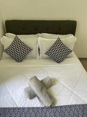a white bed with four pillows on top of it at 100Mbps DesaPark MontKiara Publika Mitec Kepong Menjalara Segambut 7Pax in Kuala Lumpur