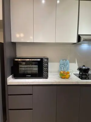 a kitchen counter with a microwave and a bowl of fruit at 100Mbps DesaPark MontKiara Publika Mitec Kepong Menjalara Segambut 7Pax in Kuala Lumpur