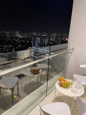 a balcony with tables and chairs and a view of a city at 100Mbps DesaPark MontKiara Publika Mitec Kepong Menjalara Segambut 7Pax in Kuala Lumpur