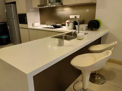 a kitchen counter with a sink and a chair at 5 Bukit Bintang 5 minutes to Alor Street Bukit Ceylon KLCC Pavilion Apt 3R2B 10 pax in Kuala Lumpur