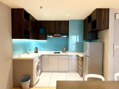 a kitchen with wooden cabinets and a refrigerator at Infini Suites@ D'Majestic Place Kuala Lumpur in Kuala Lumpur