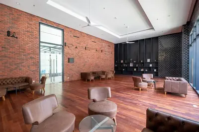 a lobby with chairs and tables and a brick wall at Chambers near PWTC SunwayPutra KLCC InfinityPool in Kuala Lumpur
