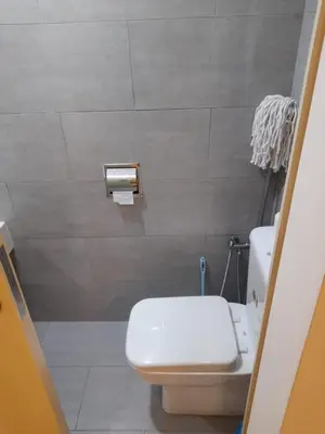 a bathroom with a white toilet and a sink at Arte Mont Kiara Pool View in Kuala Lumpur