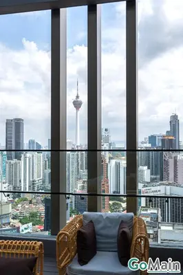 a living room with a view of a city skyline at Axon Bukit Bintang Pavillion KL KLCC by GoMain in Kuala Lumpur