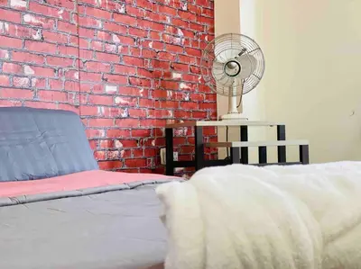 a bedroom with a brick wall and a bed and a fan at 3BR 8PAX KL City Centre KLCC View Ampang Boulevard Condo in Ampang
