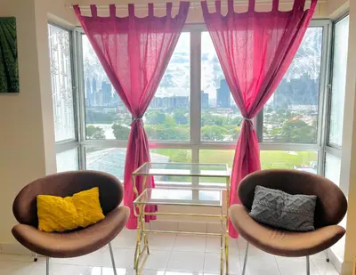 two chairs in front of a large window with pink curtains at 3BR 8PAX KL City Centre KLCC View Ampang Boulevard Condo in Ampang