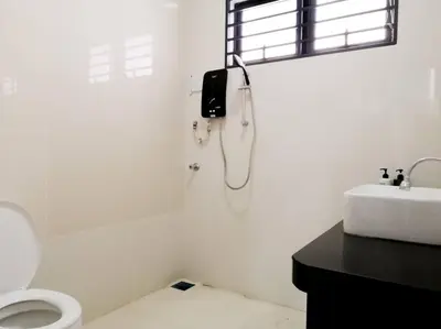 a white bathroom with a toilet and a phone on the wall at The 29 Bungalow Setapak KL by Manhattan Group in Kuala Lumpur