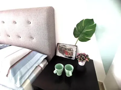 a table with two cups and a plant on a bed at MhPlatinum Gombak ShareHouse Room in Kuala Lumpur