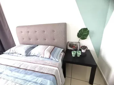 a bedroom with a bed and a table with a plant at MhPlatinum Gombak ShareHouse Room in Kuala Lumpur