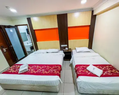two beds in a room with orange and orange walls at THE STARION HOTEL BUKIT BINTANG in Kuala Lumpur