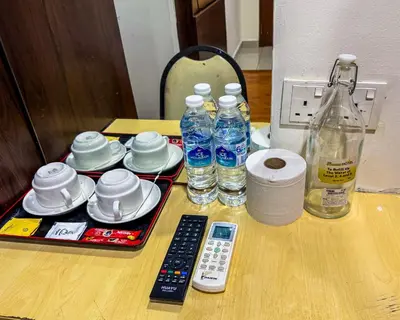 a table with a remote control and bottles of water at THE STARION HOTEL BUKIT BINTANG in Kuala Lumpur