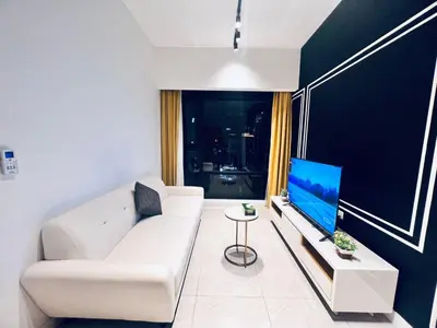 a living room with a white couch and a flat screen tv at Axon Serviced Suites Kuala Lumpur in Kuala Lumpur