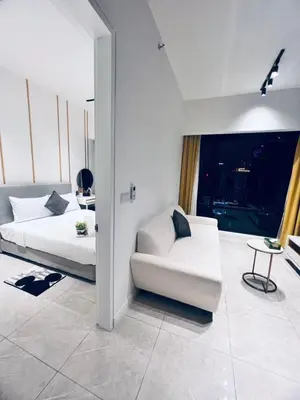 a bedroom with a bed and a couch and a chair at Axon Serviced Suites Kuala Lumpur in Kuala Lumpur