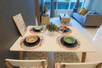 a white table with plates and glasses on it at Sky Suite KLCC, Calm Sojourn in Kuala Lumpur