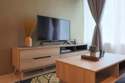 a living room with a flat screen tv on a wooden entertainment center at Sky Suite KLCC, Calm Sojourn in Kuala Lumpur