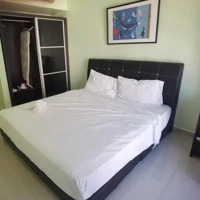 a bed with white sheets and pillows in a room at Warisan cityview jalan cheras 56000KL in Kuala Lumpur