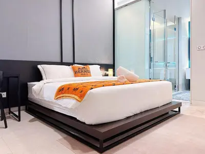 a bedroom with a large white bed with an orange blanket at Luxury Suites at Tropicana Residences KLCC by VV in Kuala Lumpur