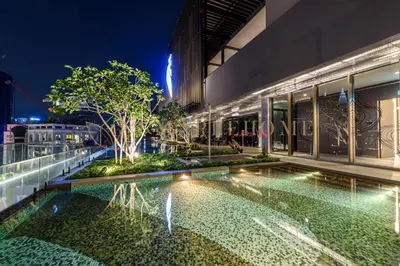 a pool in front of a building at night at Axon Premier Suites Kuala Lumpur in Kuala Lumpur