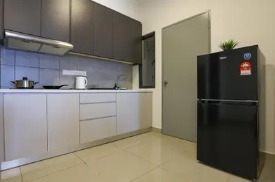 a kitchen with a black refrigerator and white cabinets at Lovely 3-bedroom w pool 7 pax - Jalan Cheras in Kuala Lumpur