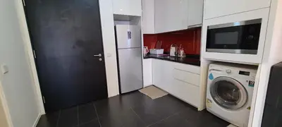 a kitchen with a washing machine and a microwave at Arcoris Mont Kiara 163 in Kuala Lumpur