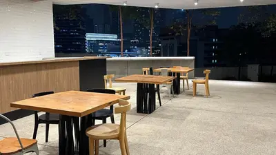 a row of wooden tables and chairs on a roof at Panoramic KL View @Robertson Bukit Bintang 40f in Kuala Lumpur