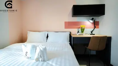 a bedroom with a bed and a desk with a computer at NeuSuite Cozy Studio by GUESTONIC in Kuala Lumpur