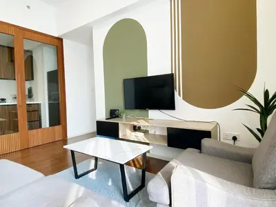 a living room with a couch and a tv at Infini Suites@ UNA Residences, Sunway Velocity KL in Kuala Lumpur