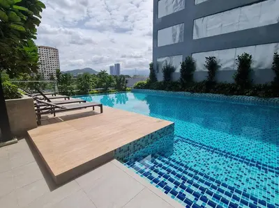 a large swimming pool with a wooden bench next to a building at Homeaway 2R1B 10 mins to KLCC in Kuala Lumpur