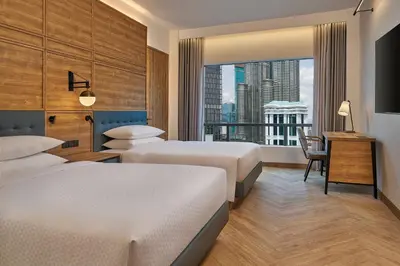 a hotel room with two beds and a window at Four Points by Sheraton Kuala Lumpur, City Centre in Kuala Lumpur