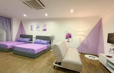 a bedroom with two beds and a chair at SETAPAK CENTRAL KL - Lavender Zetapark Suite in Kuala Lumpur