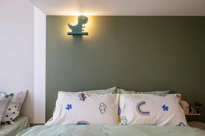 a bedroom with a bed with a light on the wall at Cute Dinosaur Kids Theme@Lucentia LalaPort BBCC in Kuala Lumpur