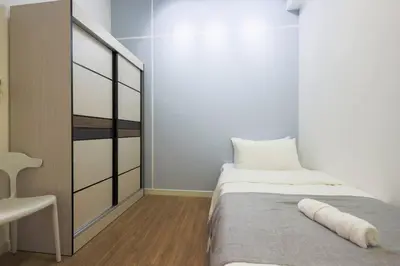 a small bedroom with a bed and a chair at M Vertica KL Residence in Kuala Lumpur