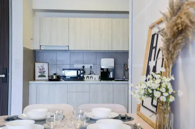 a table with plates and glasses on it in a kitchen at M Vertica KL Residence in Kuala Lumpur
