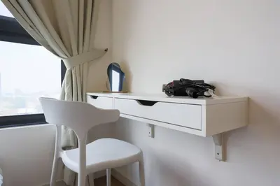 a white desk with a white chair next to a window at M Vertica KL Residence in Kuala Lumpur