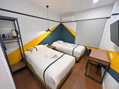a small room with two beds and a desk at Seeds Hotel Chow Kit in Kuala Lumpur