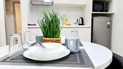 a table with a white plate and a plant on it at Kualalampur Chambers KLCC By Sky Pool in Kuala Lumpur