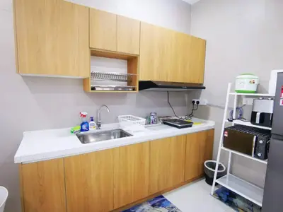 a kitchen with wooden cabinets and a sink and a refrigerator at Infinity pool! High Speed WiFi! Rica Residence! in Kuala Lumpur