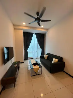 a living room with a black couch and a ceiling fan at Opus Residences 1 Bedroom Apartment in Kuala Lumpur