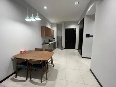 a kitchen with a wooden table and chairs in a room at Opus Residences 1 Bedroom Apartment in Kuala Lumpur