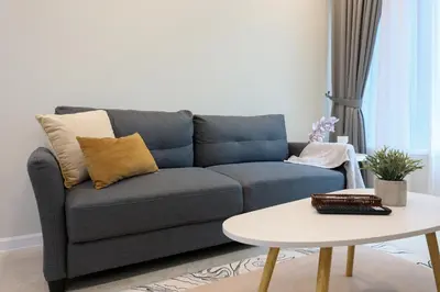 a blue couch in a living room with a table at Sky Suites KLCC By Calm Sojourn in Kuala Lumpur