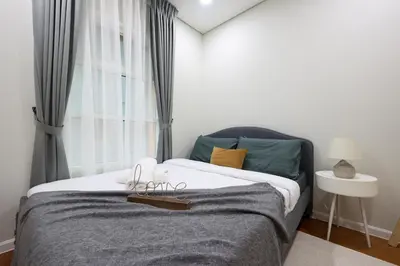 a bedroom with a large bed with a window at Sky Suites KLCC By Calm Sojourn in Kuala Lumpur