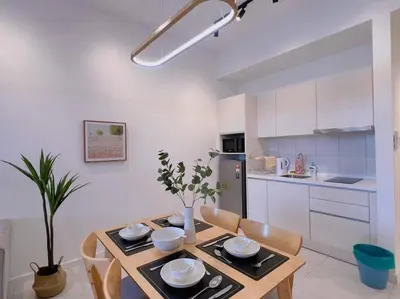 a kitchen with a wooden table with chairs and a dining room at Spacious Connecting Room 4px, Chambers Residence KL, Walking Distance to LRT, MRT, Sunway Putra Mall & PWTC in Kuala Lumpur