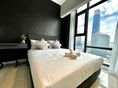a bedroom with a white bed with a large window at Axon Suites Bukit Bintang by Prestige in Kuala Lumpur