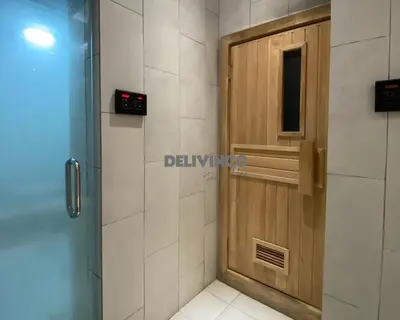 a bathroom with a wooden door and a shower at The Luxe - 3 pax - KLCC View - Balcony at 27 floor in Kuala Lumpur