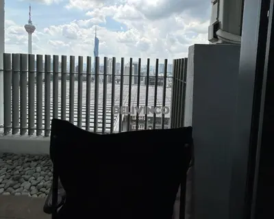 a black chair sitting on a balcony with a fence at The Luxe - KLCC View - 3 pax Balcony at 41 floor in Kuala Lumpur