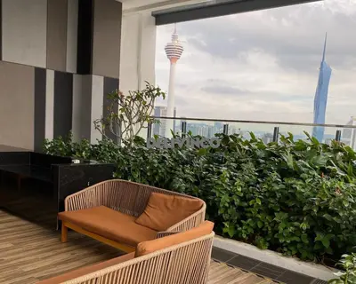 a chair on a balcony with a view of the city at Stylish AeroSpace Theme 1BR in KL City Center in Kuala Lumpur